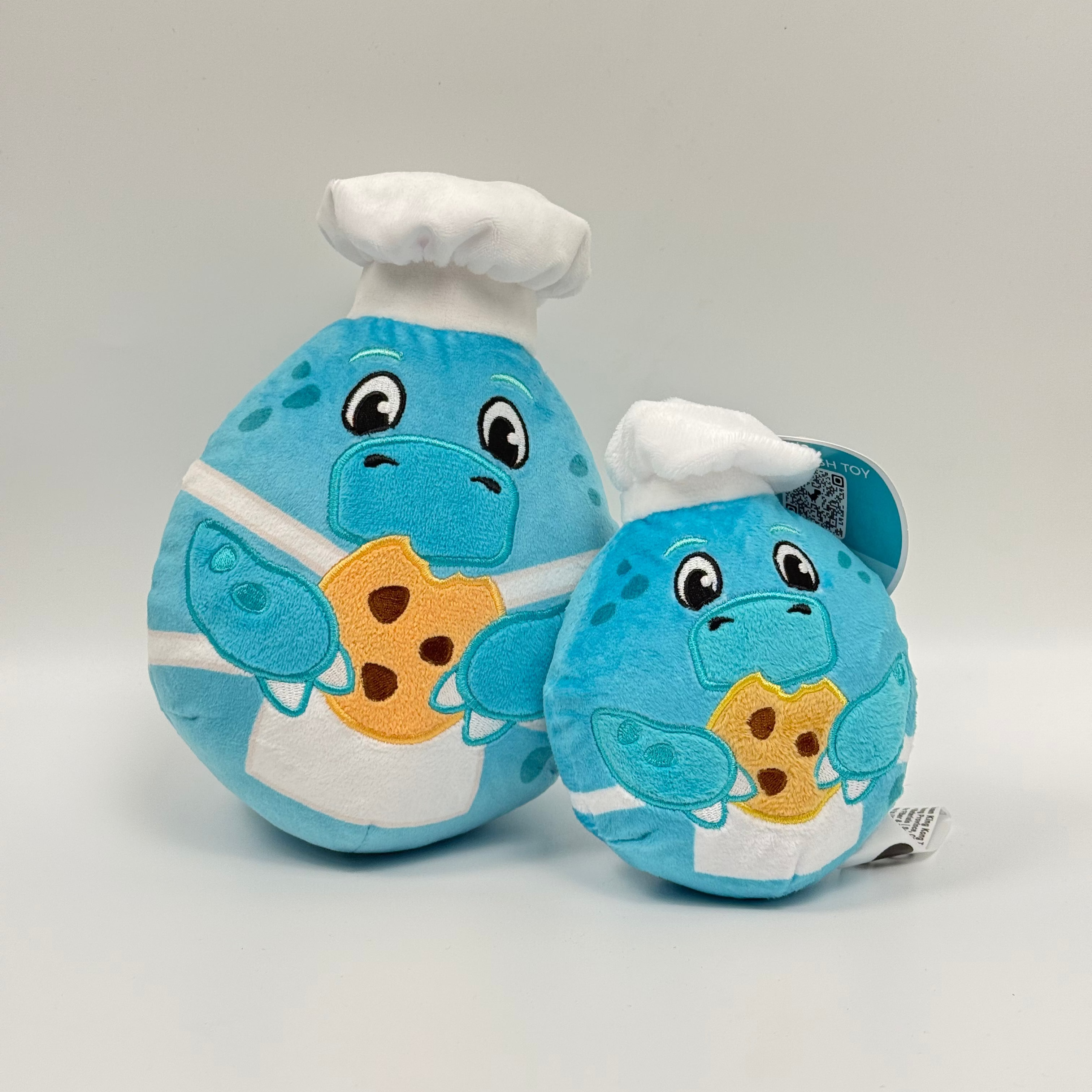Dino themed plushie toys holding a cookie